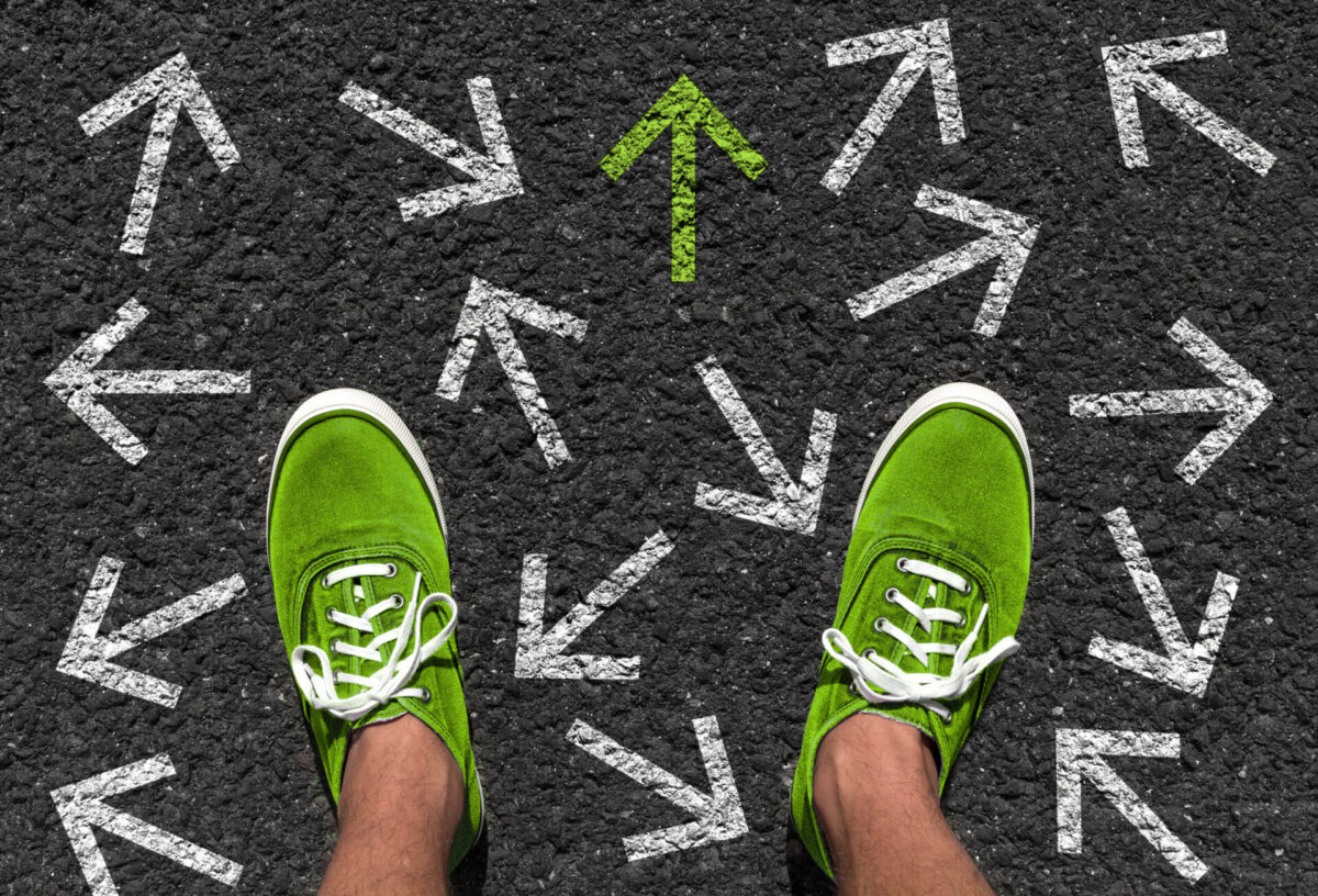 矢印と緑の靴を履いた男性の足元