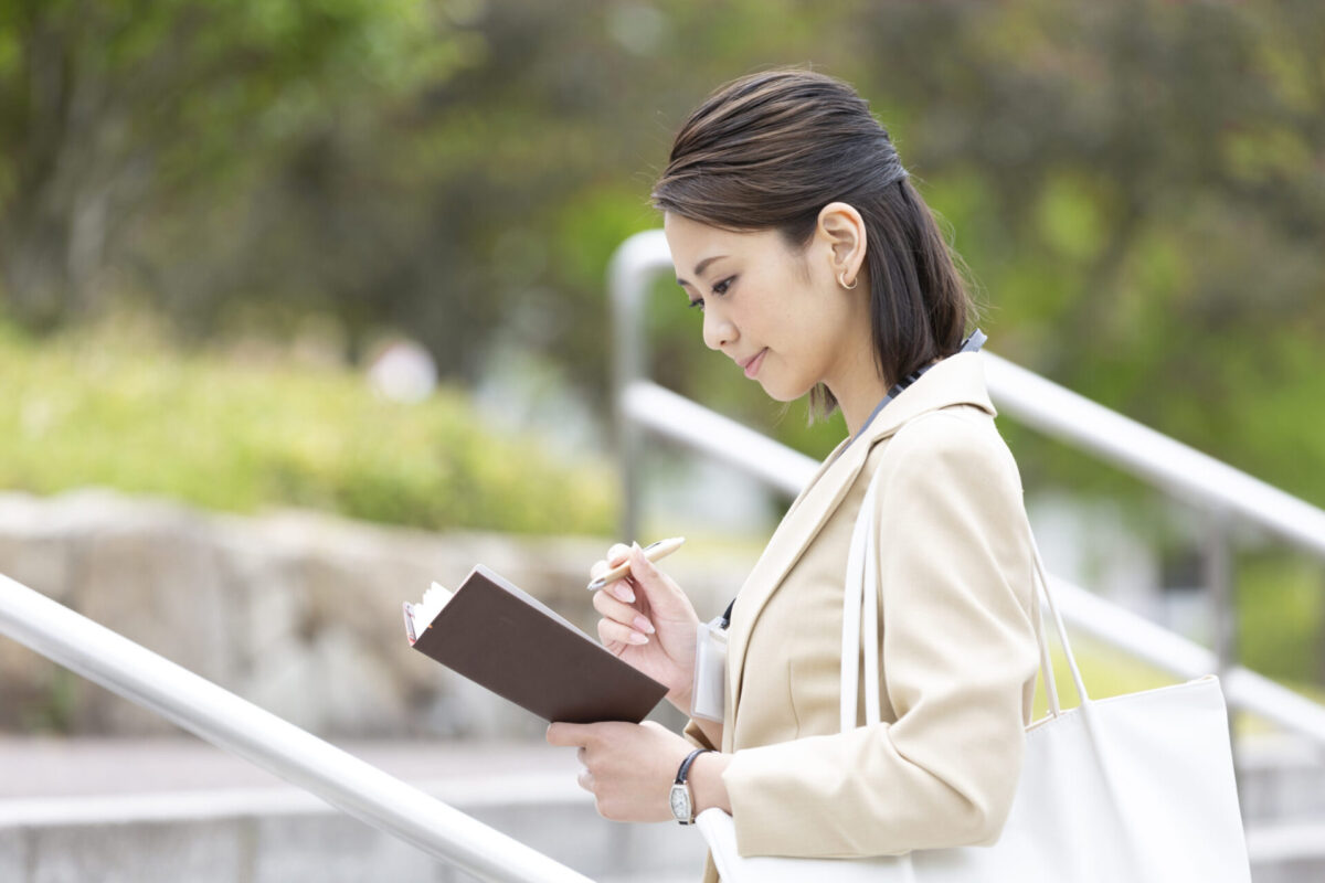 就職活動の予定を手帳で確認する女性