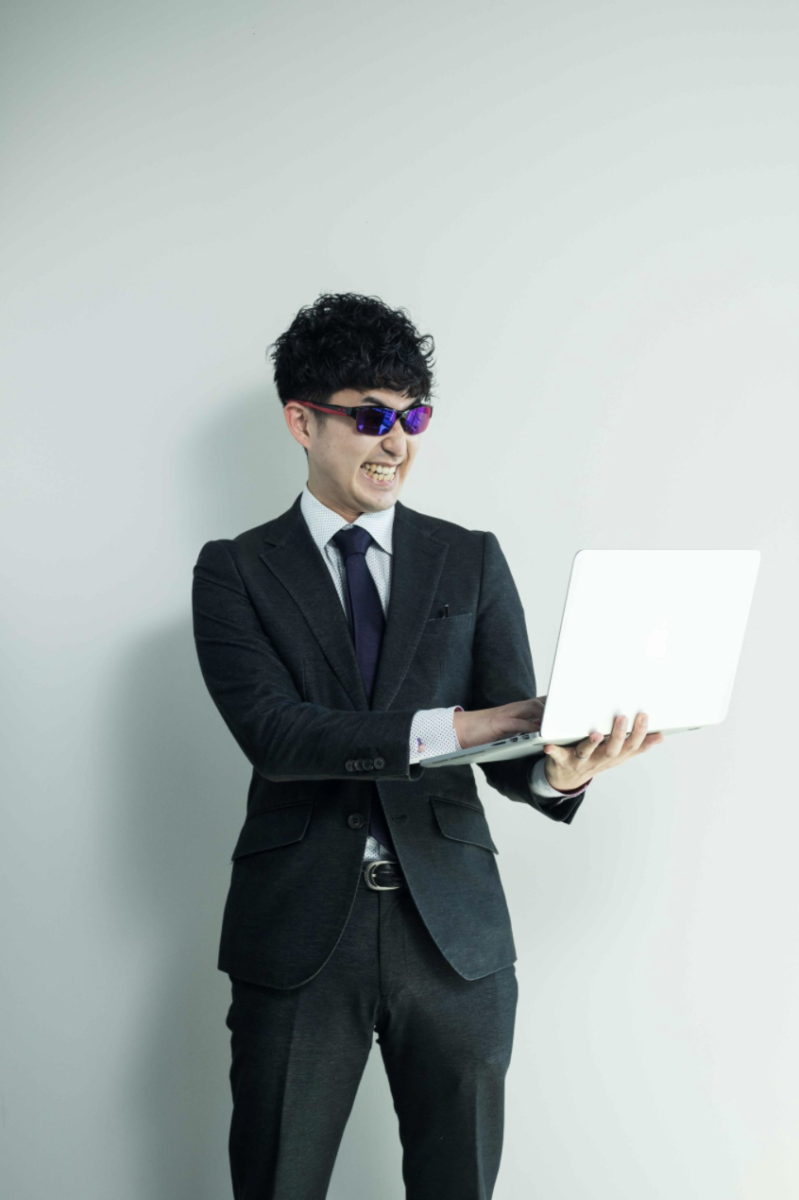 サングラスをかけてパソコンを触る山本純平