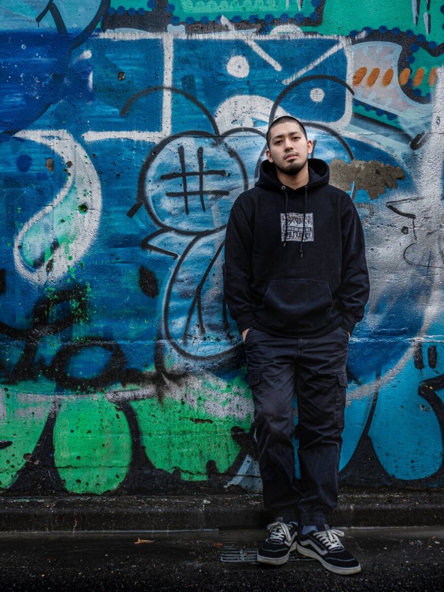 個性的な壁の前に立つ一條恭輔