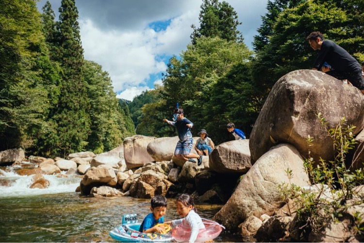 川で楽しそうに遊ぶ子どもたち