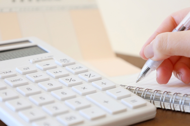 電卓片手に仕事をしている写真