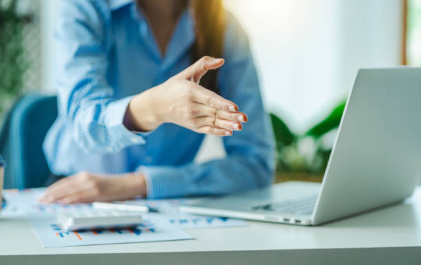 oung asian business woman stretching hand at camera in greeting gesture.