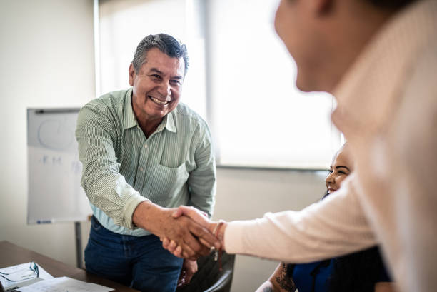 Coworkers greeting and doing a handshake at work