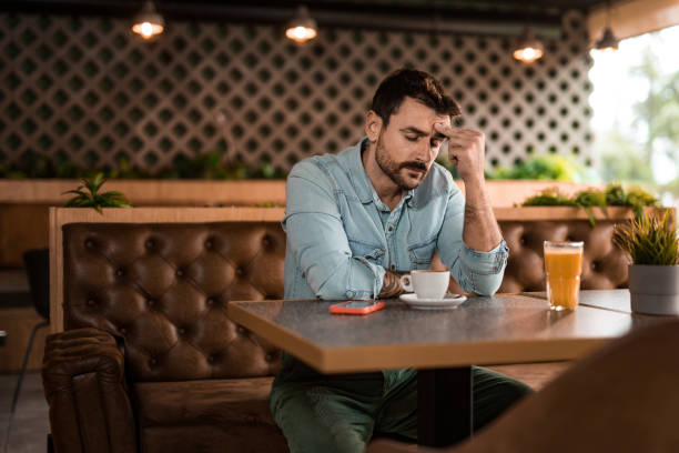 Depressed young man taking a break in cafe.