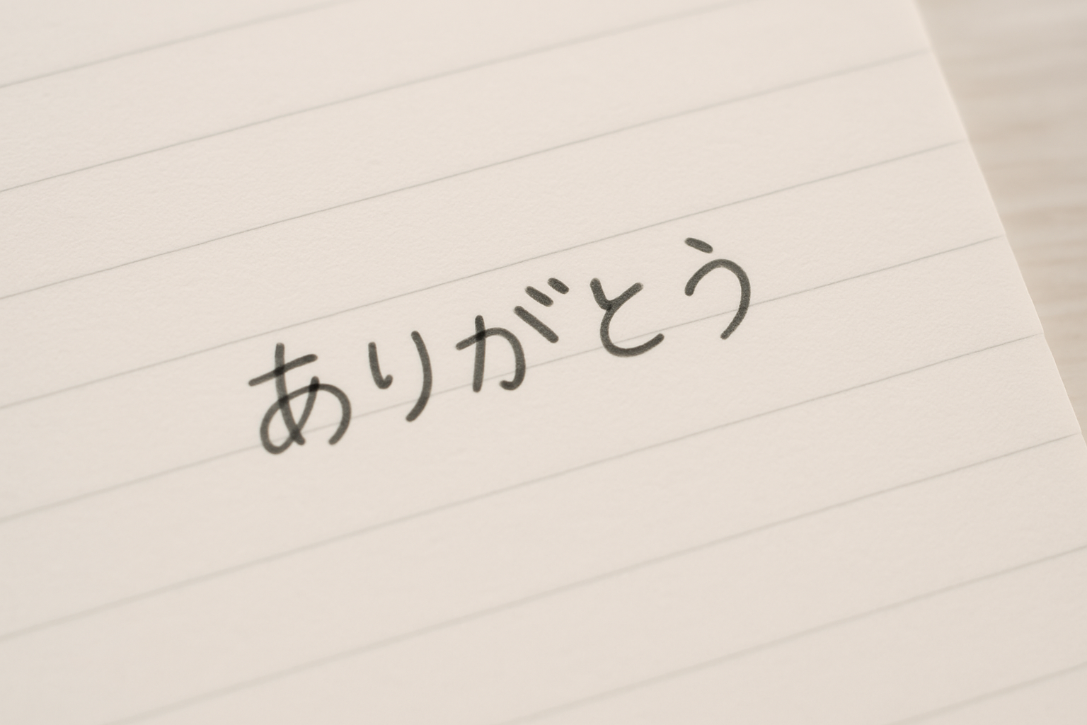 A soft, handwritten note on a clean notebook page. The handwriting is slightly rounded but very neat, showcasing the balance between cuteness and cleanliness. The words could be something simple like "ありがとう" or "こんにちは".