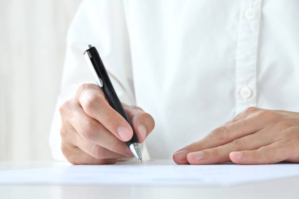 Woman's hand signing contract sheet